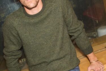 man wearing a green crewneck sweater with jeans