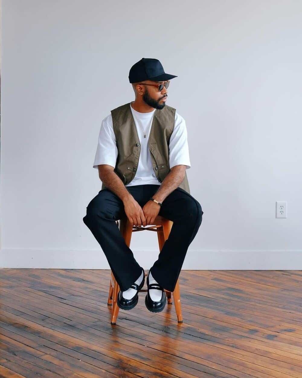 man sitting on a stool wearing a pair of Arezzo loafers by KOIO