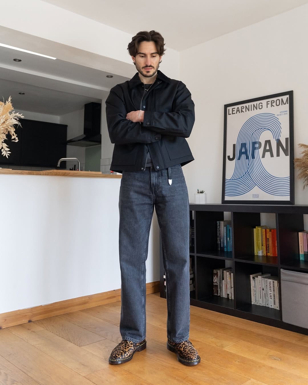 stylish man wearing a black jacket, black jeans, and black western-style belt