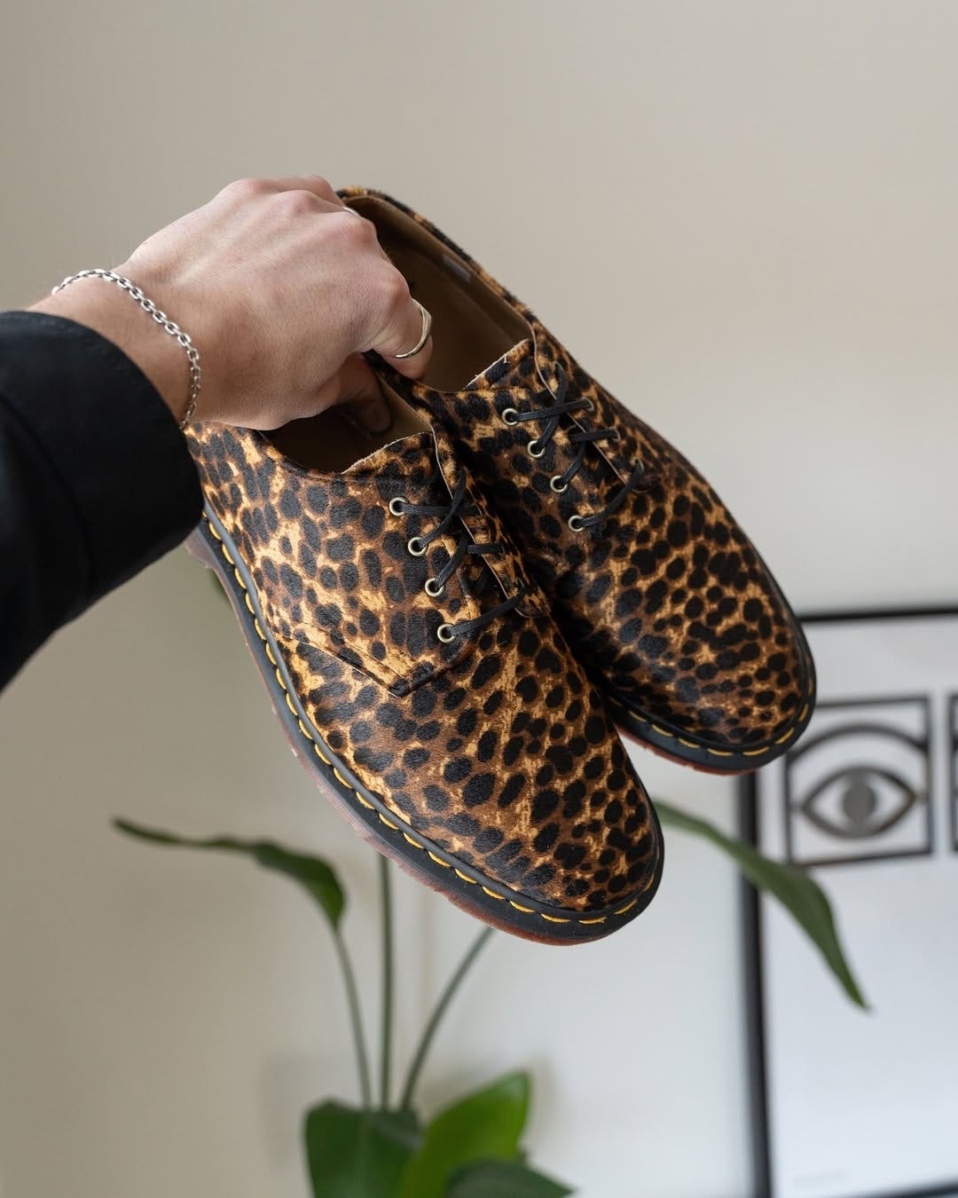 close-up of a pair of leopard-print lace-up doc marten shoes