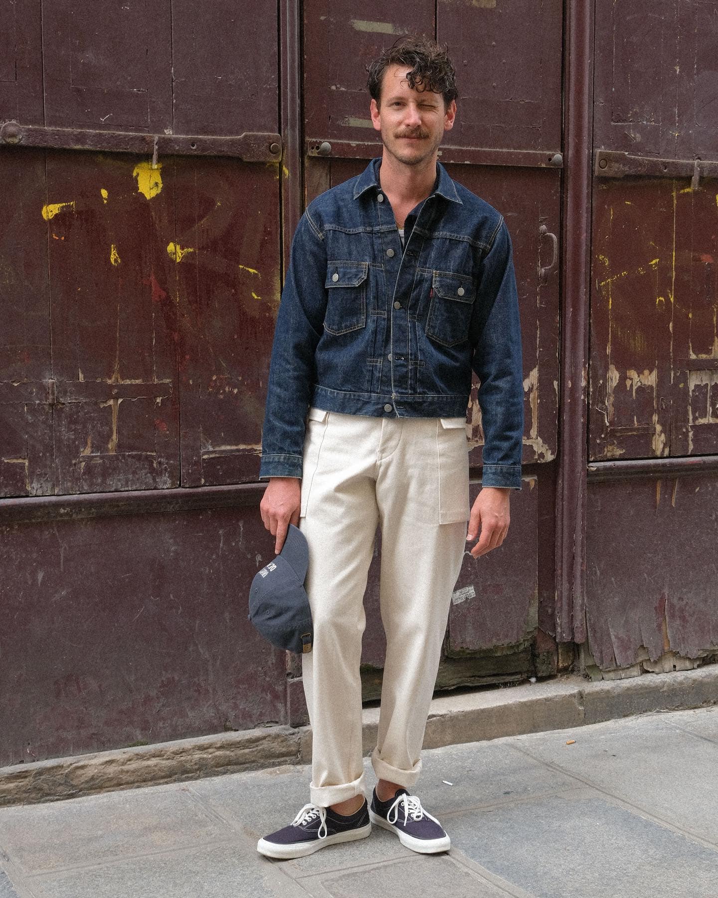 man in denim jacket giving a wink