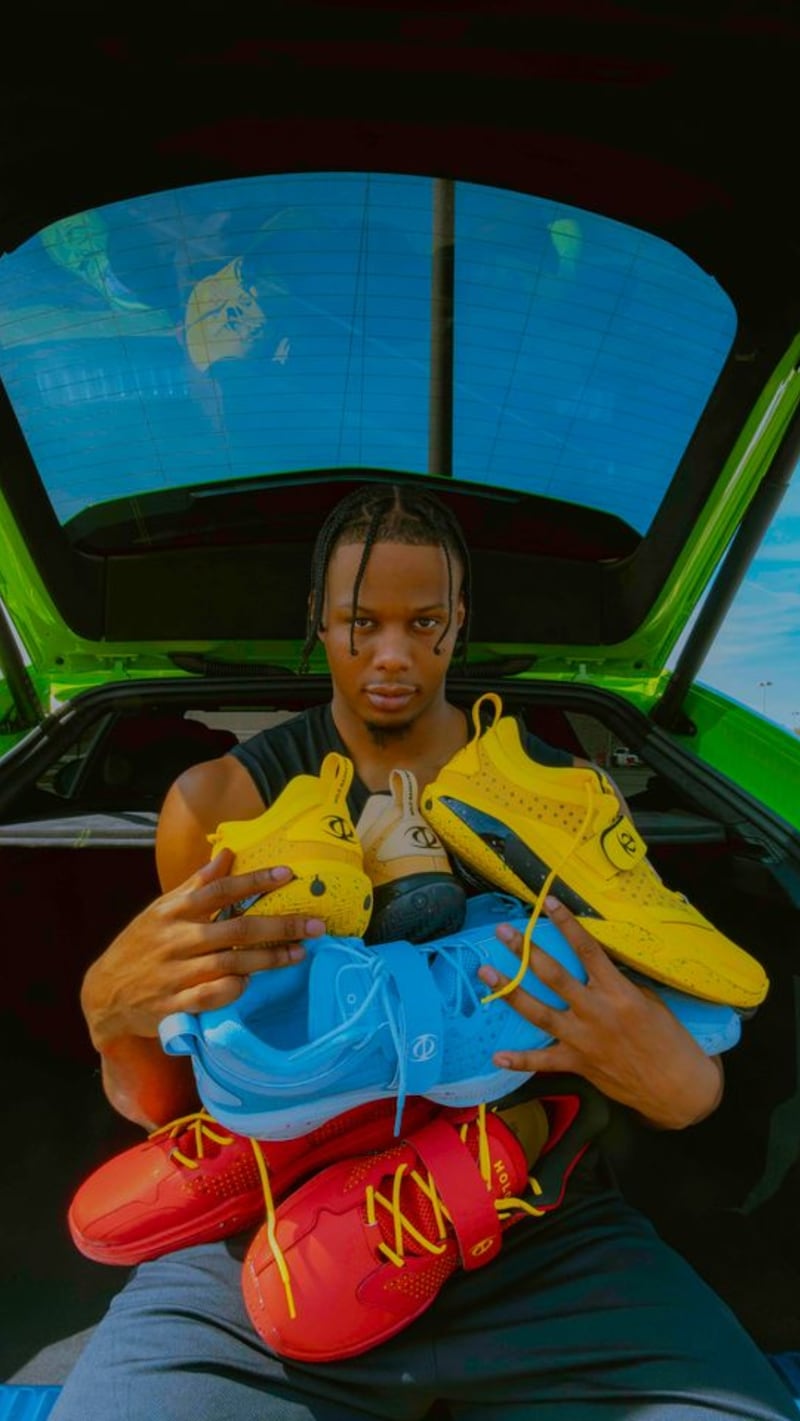 Isaak Okoro holds his signature sneakers