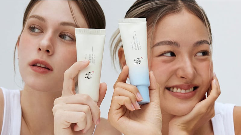 Models holding bottles of Beauty of Joseon sunscreens.