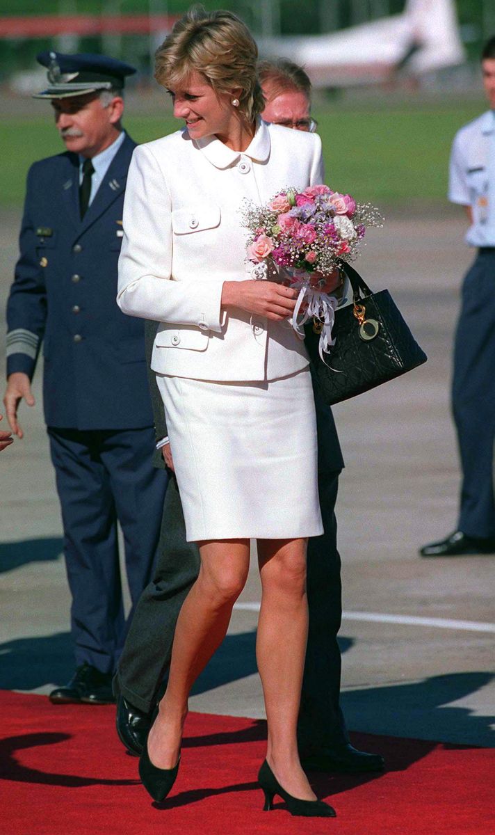 BUENOS AIRES, ARGENTINA - NOVEMBER 23:  Princess Diana Arriving At Buenos Aires Airport For Her Historic Visit To Argentina. The Princess Is Wearing A White Suit Designed By Fashion Designer Versace And She Is Carrying A Black Christian Dior Handbag.  (Photo by Tim Graham Photo Library via Getty Images)