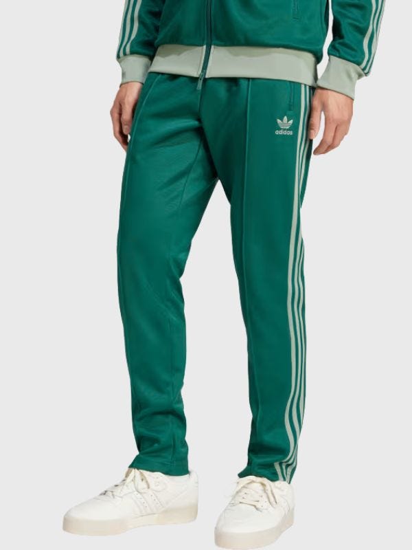 man from the waist down wearing green Adidas track pants