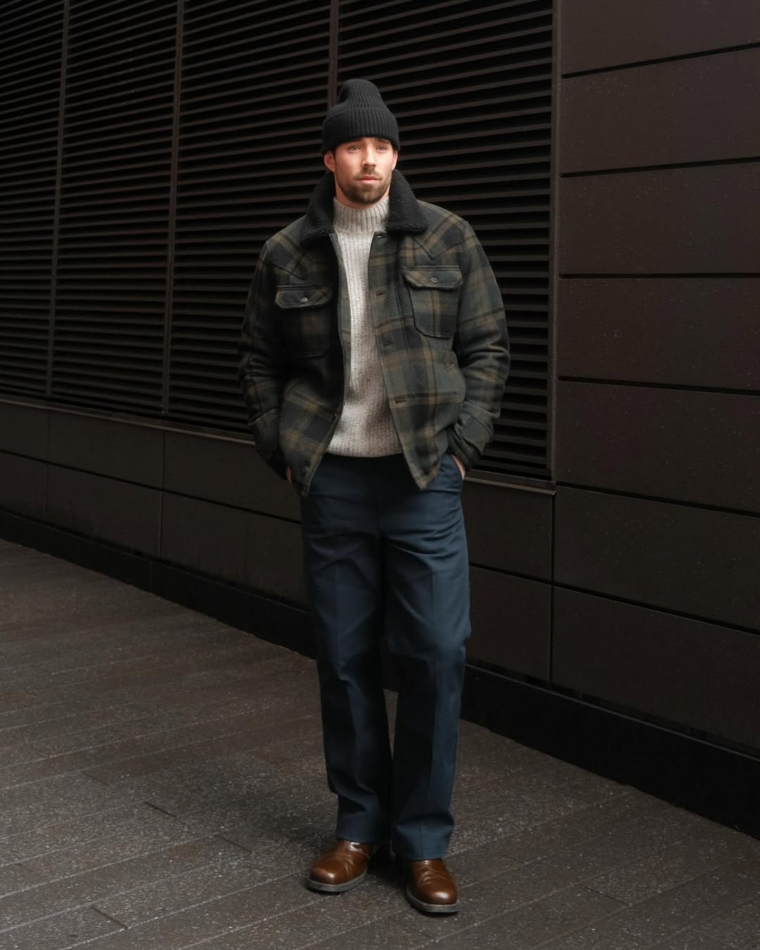 stylish man wearing a grey turtleneck with navy pants and a plaid jacket