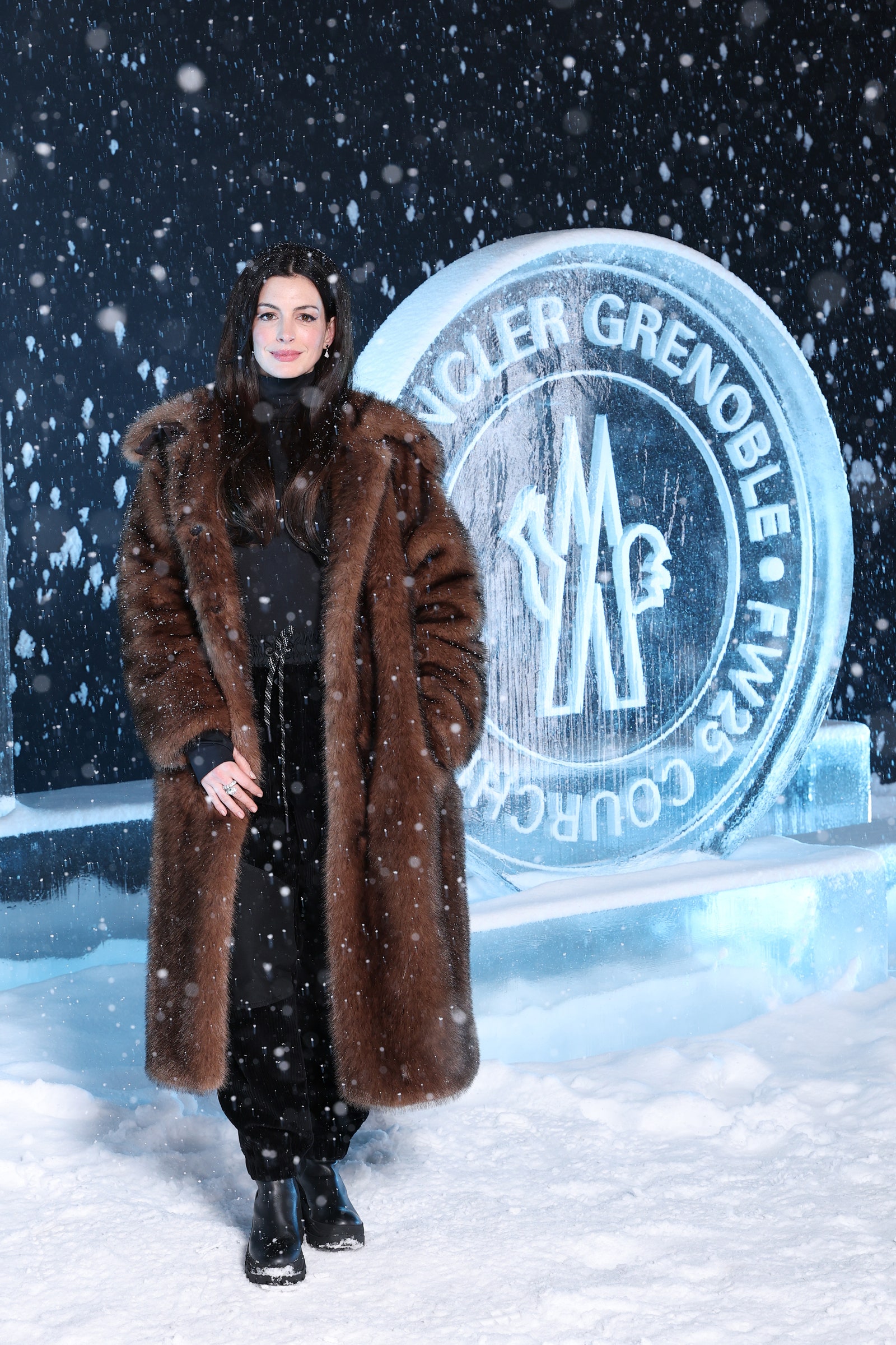 Image may contain Anne Hathaway Clothing Coat Adult Person Footwear Shoe Accessories Jewelry Ring and Winter