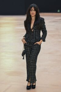 Camila Cabello attends the Chanel Fall/Winter 2025-2026 show wearing a chic plaid suit, accompanied by her boyfriend Henry Junior Chalhoub.