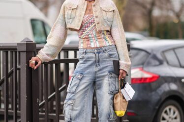 PARIS FRANCE  MARCH 05 A guest wears brown sunglasses triangular earrings a tweed jacket  a necklace  a colored lowneck...