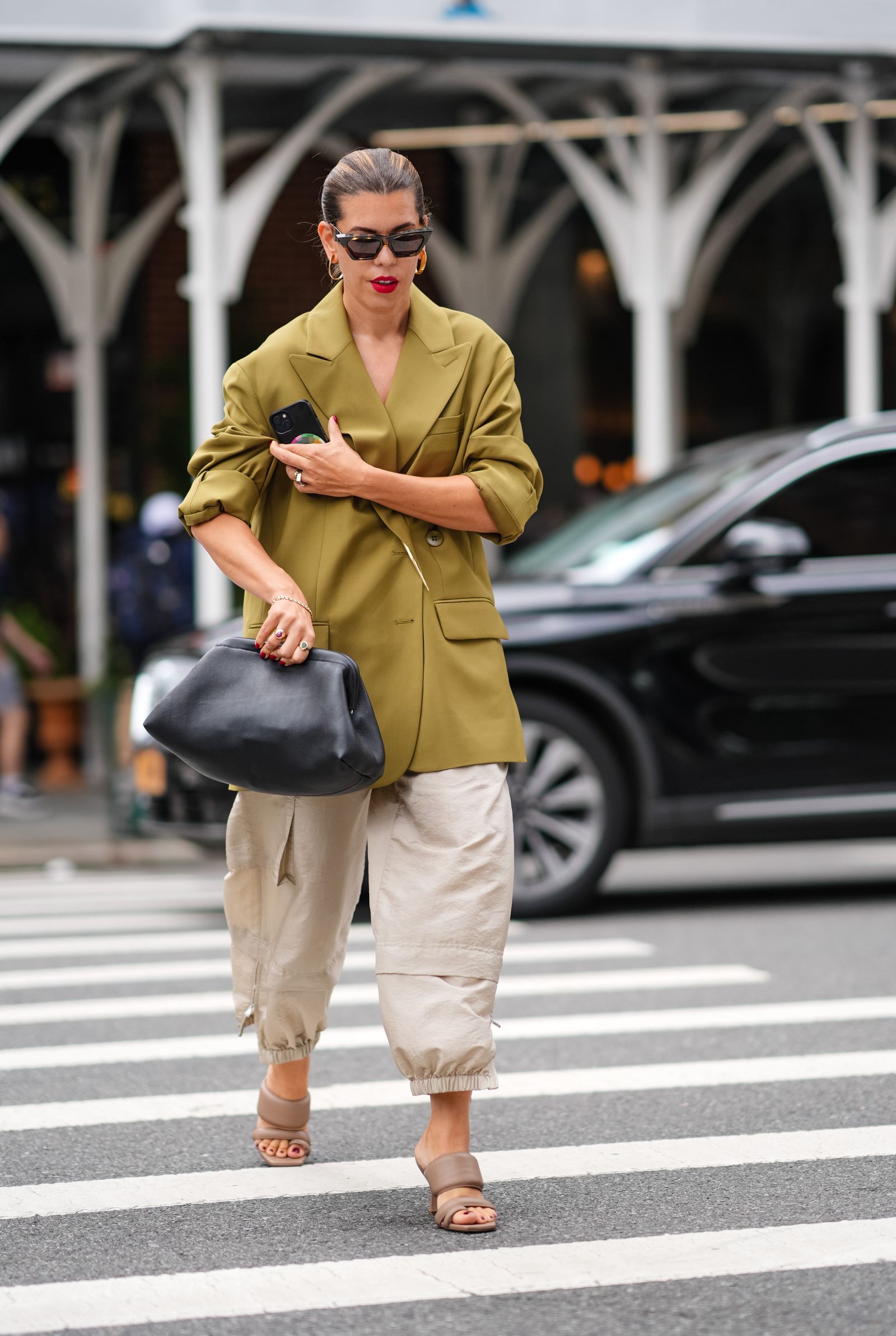 NEW YORK NEW YORK  SEPTEMBER 07 A guest wears black sunglasses gold hoop earrings dark green oversized blazer jacket...