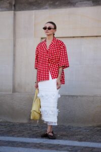 COPENHAGEN DENMARK  AUGUST 6 A guest wears black sunglasses gold earrings white and red pattern button up short sleeve...