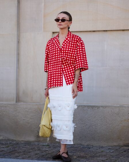 COPENHAGEN DENMARK  AUGUST 6 A guest wears black sunglasses gold earrings white and red pattern button up short sleeve...